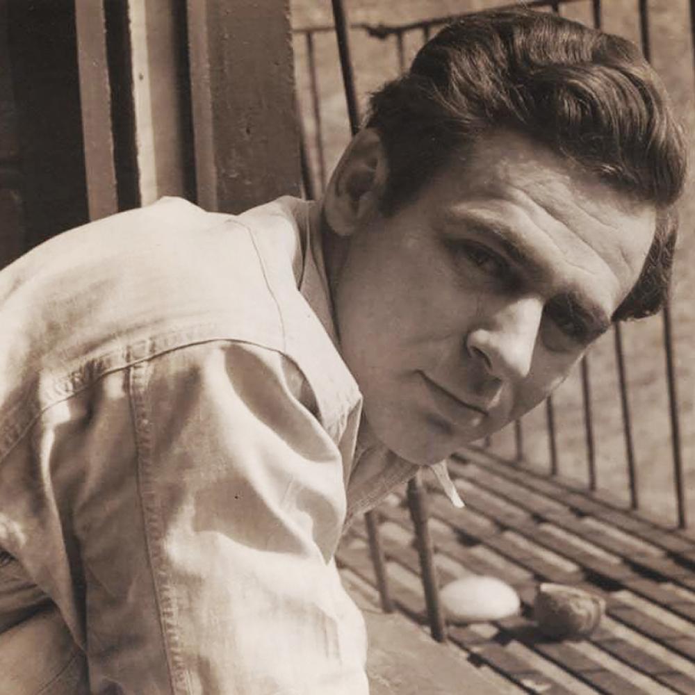 Sepia-colored photo portrait of James Agee leaning in at an angle.