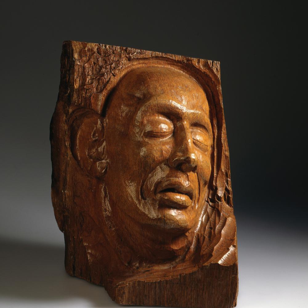 wood relief sculpture of a grieving face