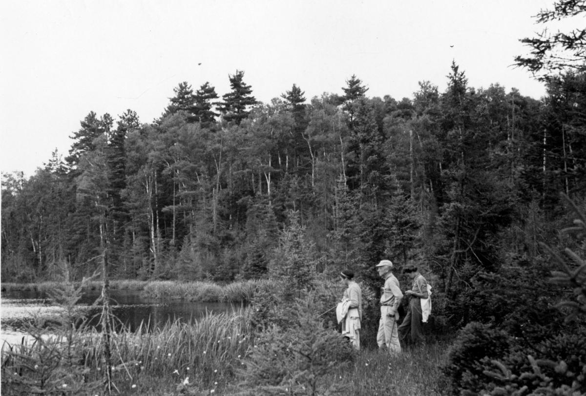 Black and white landscape photo with three people in foreground