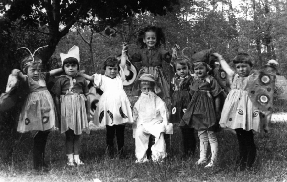 Black and white photo of children, in various costumes.