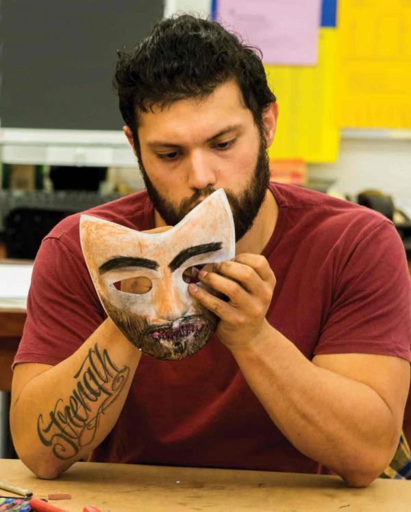 Veteran C. J. Villanueva paints a mask. 