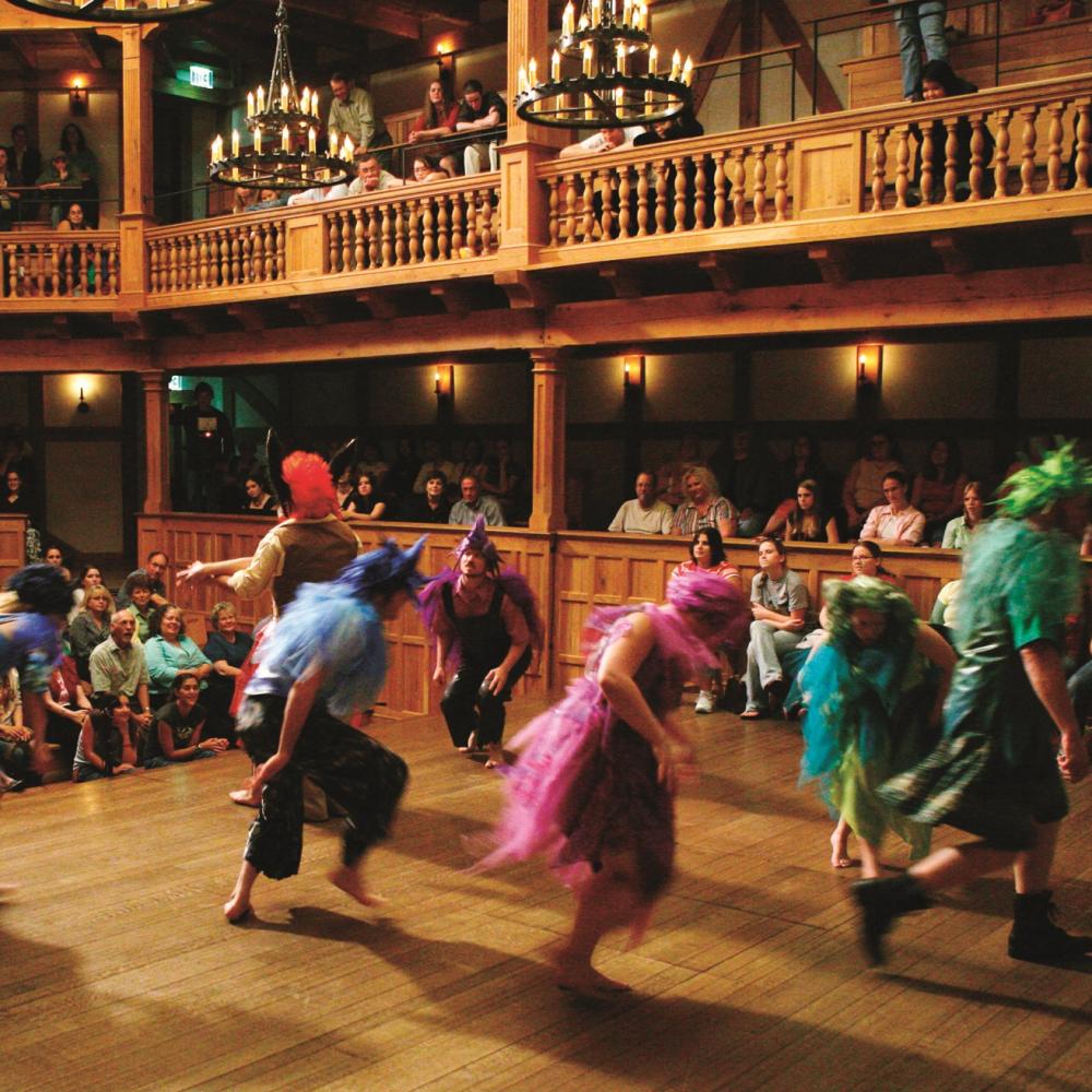 performers in colorful costumes moving around on stage