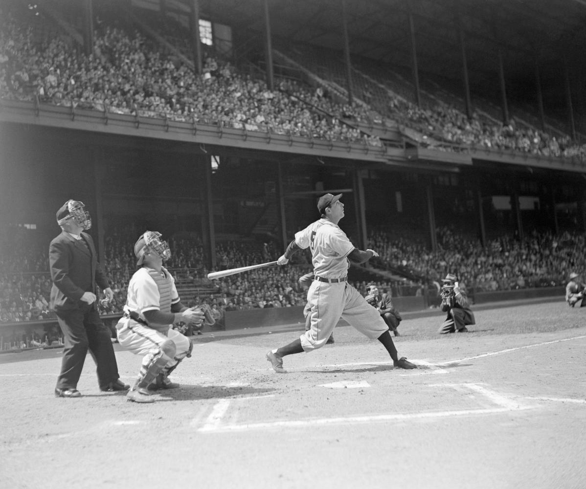 Greenberg holding his bat at home plate, watching his hit and getting ready to run