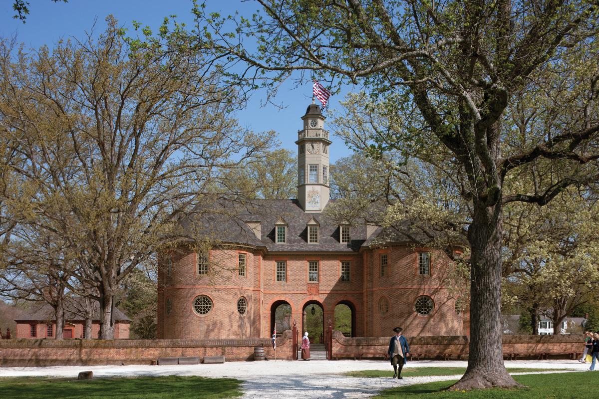 Modern exterior of the Capitol building, done in red brick, shaded by trees