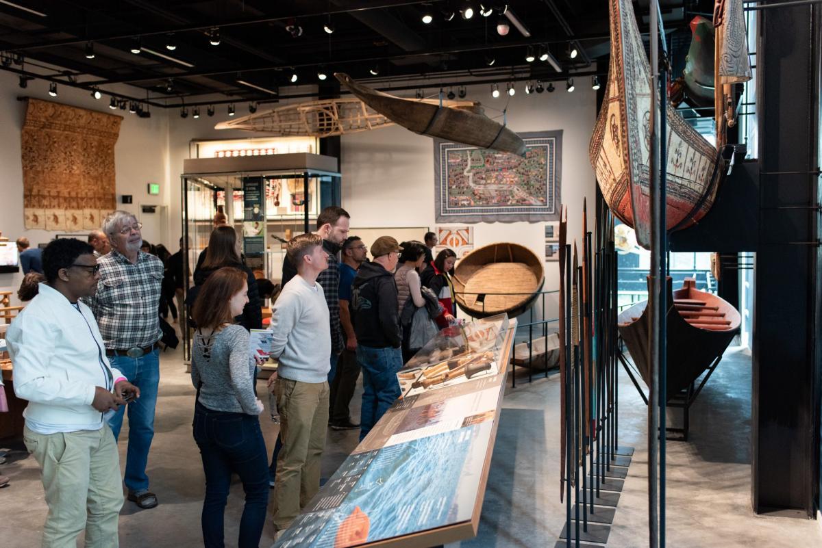 Visitors tour the Culture is Living exhibit at the Burke Museum.