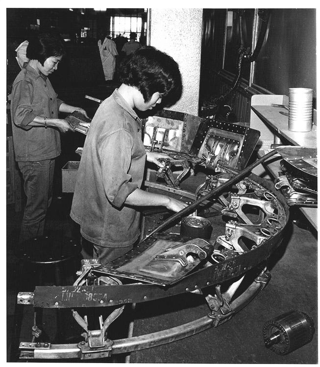 The staff at the Air Vietnam Technical Services Center included many women. They are reassembling the engine cowling of an overhauled passenger plane.