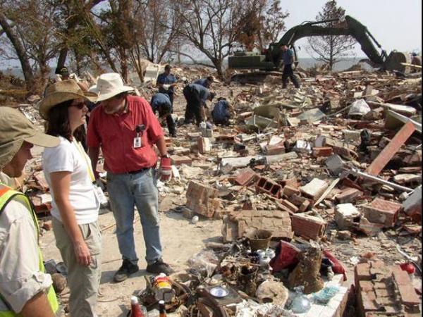 Man standing over Hurricane wreckage