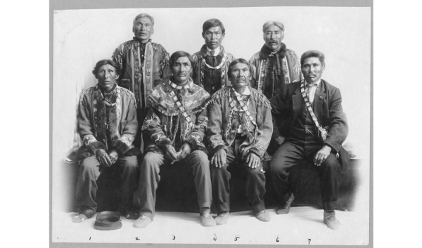 Group of Native American men, half seated, half standing up