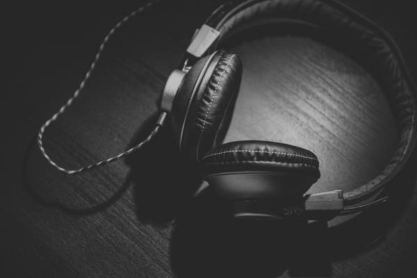 Black headphones lying on a black tabletop