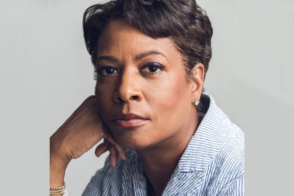 a headshot of Dawn Porter wearing a blue-and-white seersucker jacket.