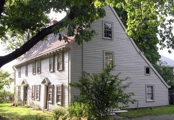 Image of white wooden Historic New England home with a tree in the foreground