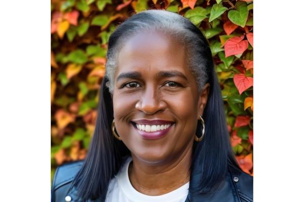 Robin Harris in a leather jacket, autumnal leaves changing color in the background