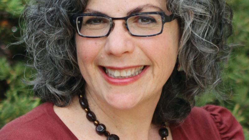 Color photo of Paula A. Michaels wearing glasses and a red blouse.