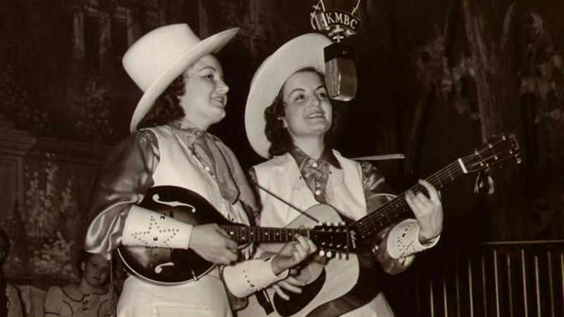 Kitty & Kay performing with guitar and mandolin.