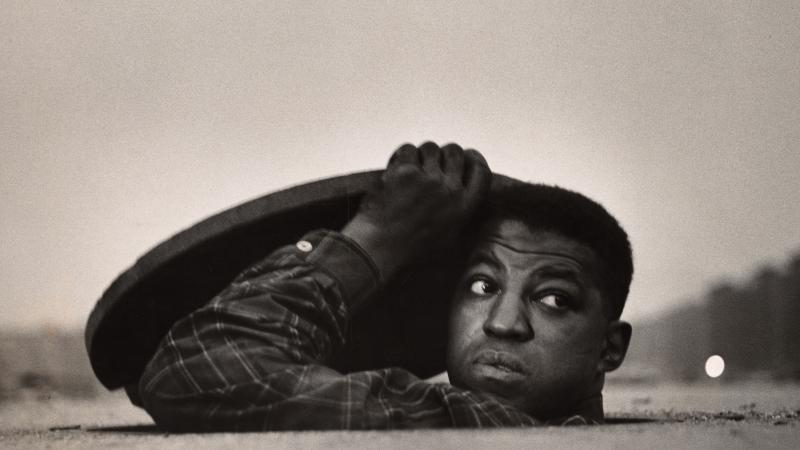 A man pokes his head out of a manhole.